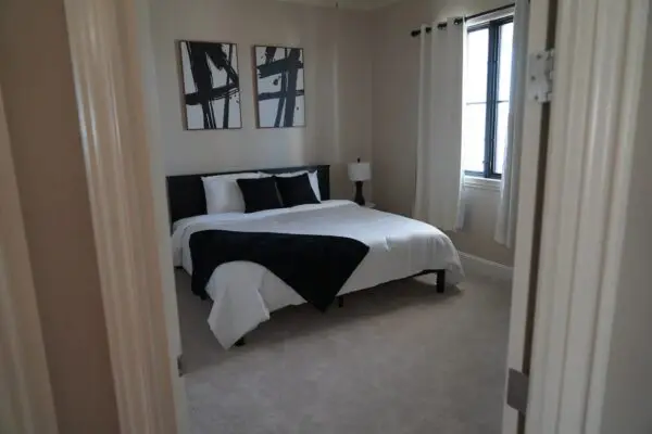 A Bedroom Space With White Color Bedsheets