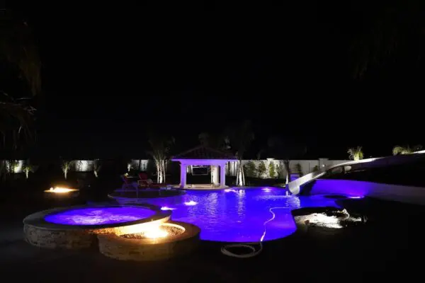 A Pool Area With Lights Lighting the Water